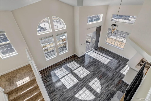 living room featuring a high ceiling and baseboards