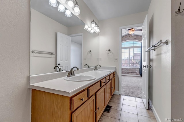 full bathroom with double vanity, baseboards, a sink, and tile patterned floors