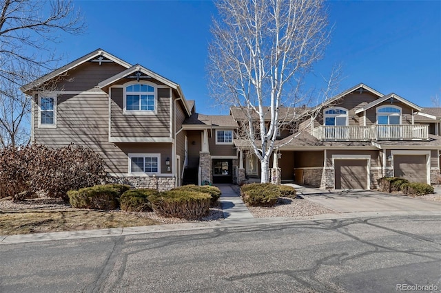 view of front of property with a garage, stone siding, and concrete driveway