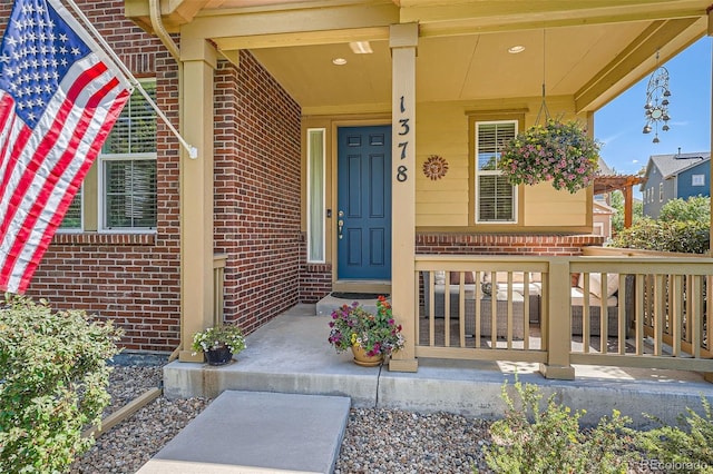 property entrance with brick siding and a porch