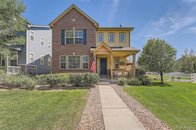 view of front of house with brick siding, a porch, and a front yard