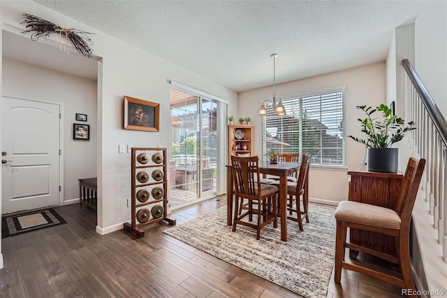 dining room with dark wood-style floors, a textured ceiling, and baseboards