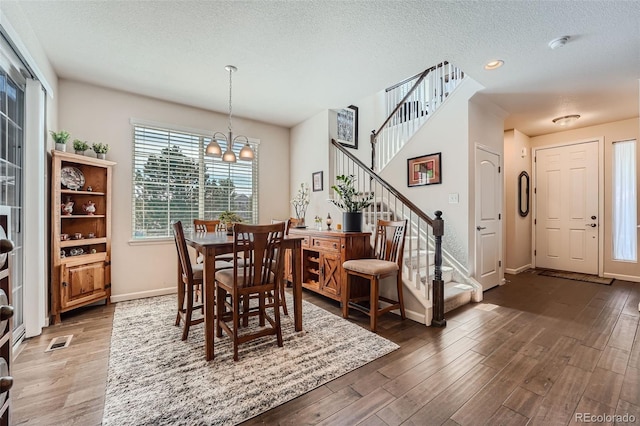 dining space featuring stairs, wood finished floors, and visible vents