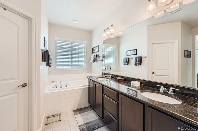 bathroom with tile patterned floors, double vanity, a bath, and a sink