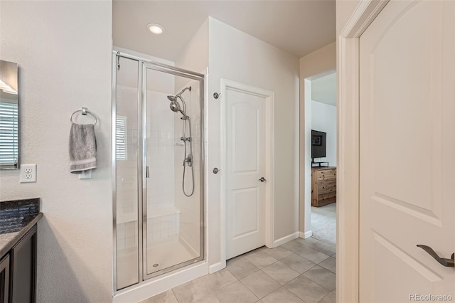 full bath with tile patterned flooring, a shower stall, vanity, and baseboards