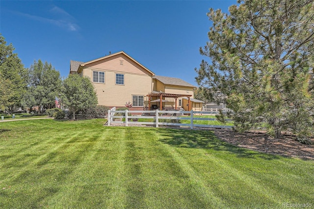 rear view of house with a lawn and fence