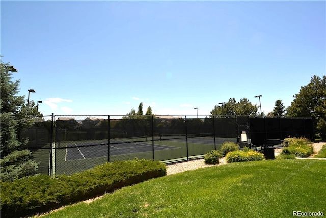 view of sport court featuring a yard and fence