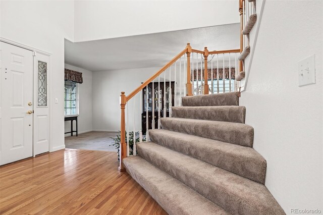 foyer with light wood finished floors and stairway