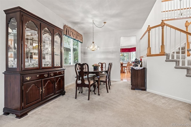 dining room with stairs, light carpet, a chandelier, and baseboards