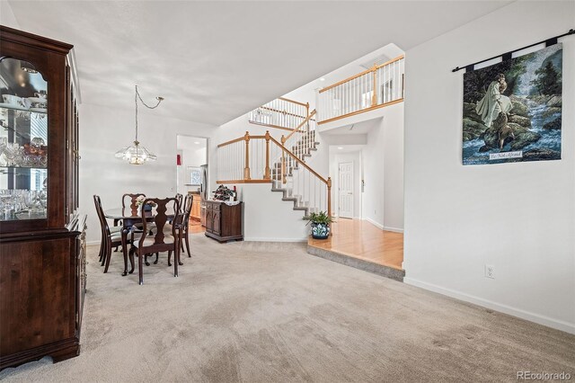 carpeted dining room with stairs, baseboards, and a chandelier