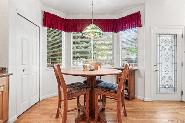 dining area featuring light wood finished floors and baseboards