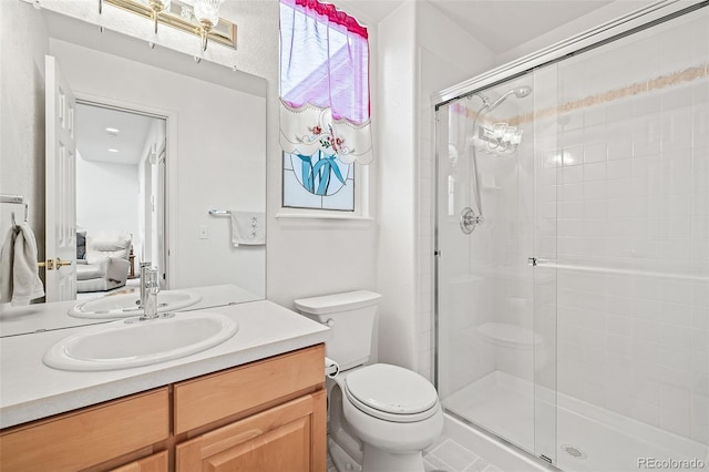 ensuite bathroom featuring toilet, a stall shower, and vanity