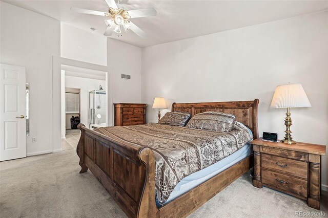 carpeted bedroom with baseboards, ensuite bath, and ceiling fan