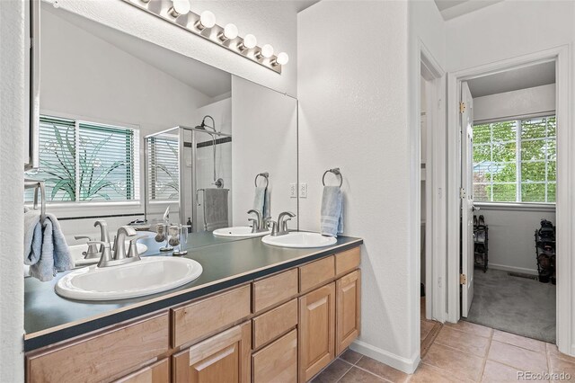 bathroom featuring a stall shower, tile patterned flooring, and double vanity