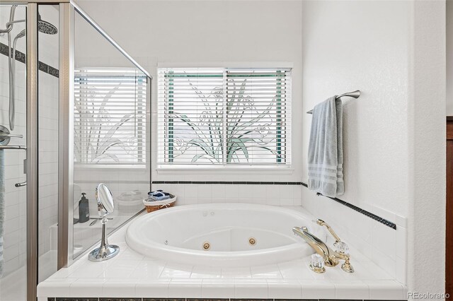 full bath with a tub with jets and a shower stall