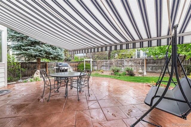 view of patio with outdoor dining area, a fenced backyard, and area for grilling