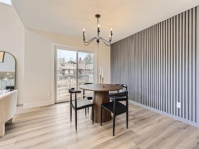 dining room with light hardwood / wood-style flooring and a notable chandelier