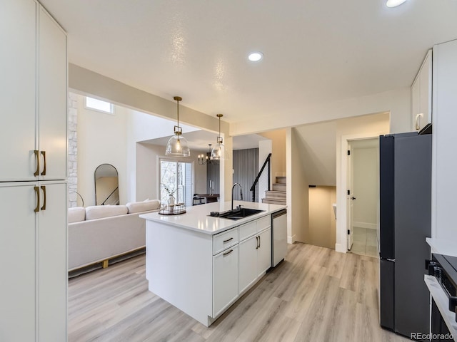 kitchen with sink, white cabinetry, decorative light fixtures, black refrigerator, and stainless steel dishwasher