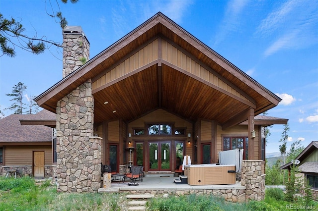 back of property featuring french doors, a hot tub, and a patio