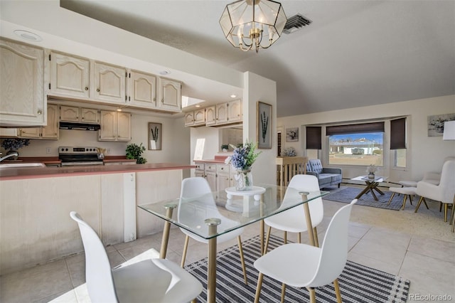 dining space with light tile patterned flooring, vaulted ceiling, visible vents, and an inviting chandelier