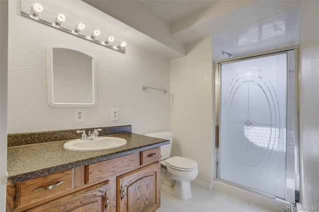 bathroom featuring a stall shower, vanity, and toilet