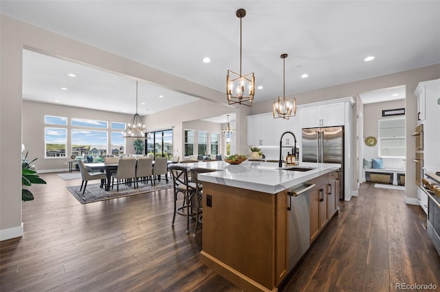 2144 Bellcove Dr, Castle Pines, CO 80108 - kitchen with a chandelier, a sink, a large island, stainless steel appliances, and light stone counters