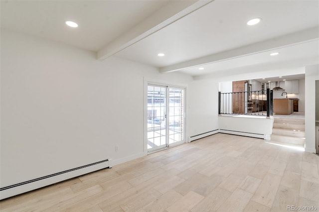 spare room with baseboard heating, light hardwood / wood-style floors, and beam ceiling