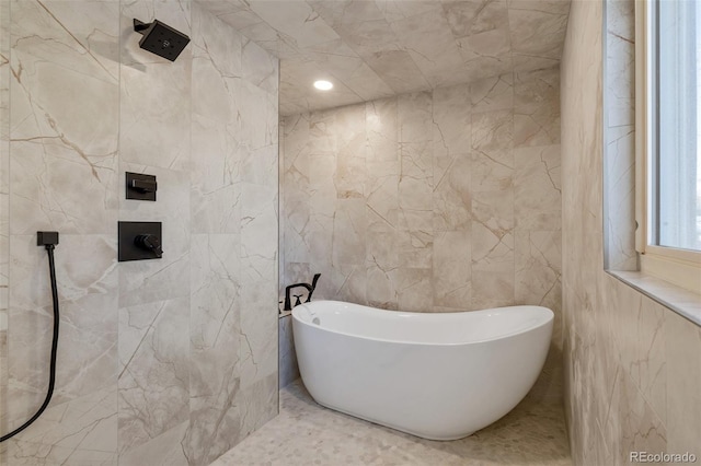 bathroom with a bath and tile walls