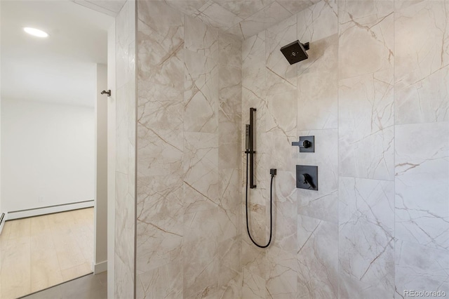 bathroom with a baseboard heating unit and tiled shower