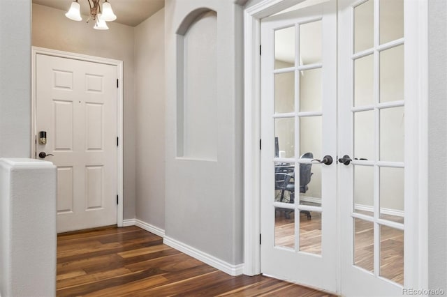 entryway featuring baseboards, a chandelier, dark wood-style floors, and french doors