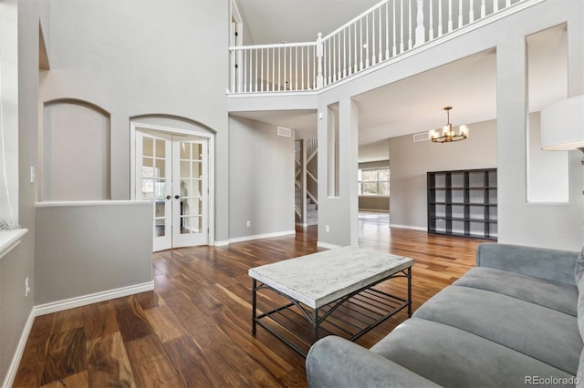 living area featuring visible vents, stairs, wood finished floors, baseboards, and french doors