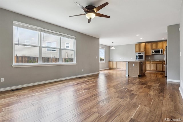 unfurnished living room with visible vents, dark wood-style flooring, baseboards, recessed lighting, and a ceiling fan