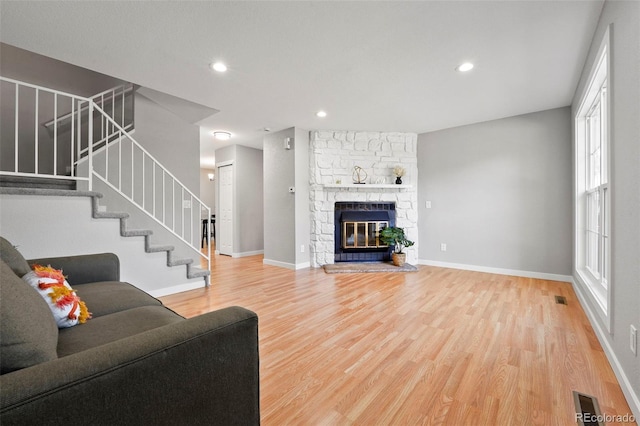 living room featuring hardwood / wood-style floors and a stone fireplace