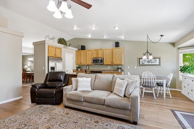 2169 Fox Fire St, Highlands Ranch, CO 80129 - living area with a chandelier, light wood finished floors, vaulted ceiling, and ceiling fan
