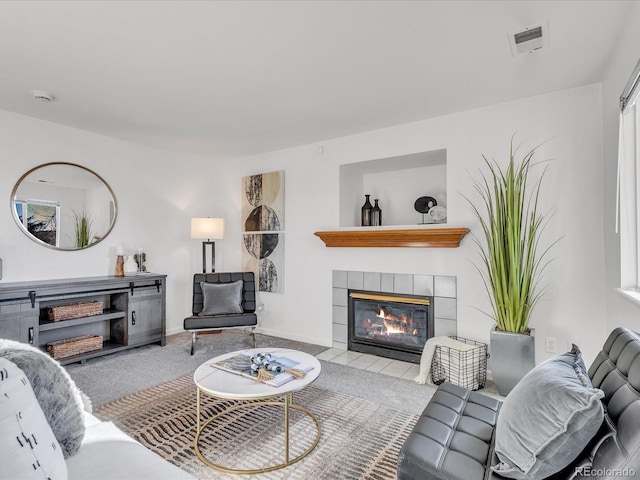 living room featuring light colored carpet and a tile fireplace