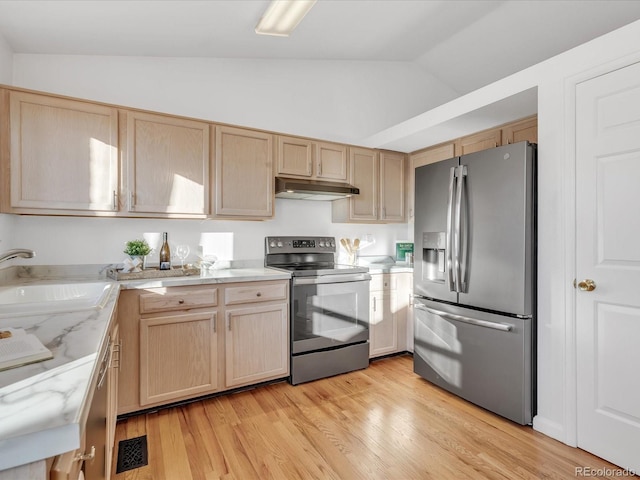 kitchen featuring lofted ceiling, sink, light hardwood / wood-style flooring, stainless steel appliances, and light brown cabinetry