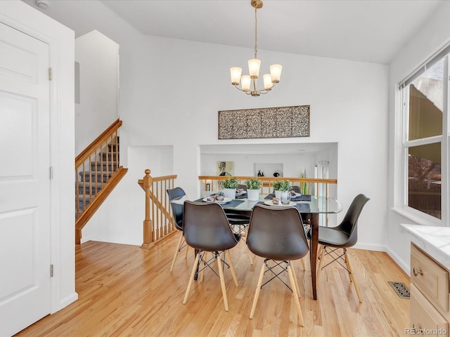 dining space featuring light hardwood / wood-style floors and an inviting chandelier