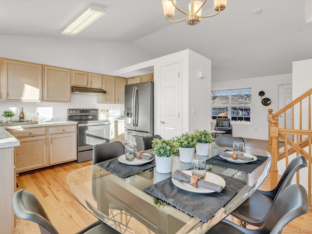 dining space with light hardwood / wood-style flooring, lofted ceiling, and a chandelier