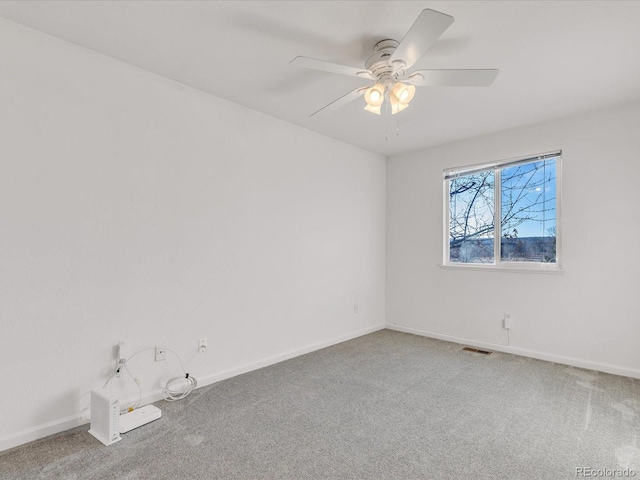 empty room featuring ceiling fan and carpet