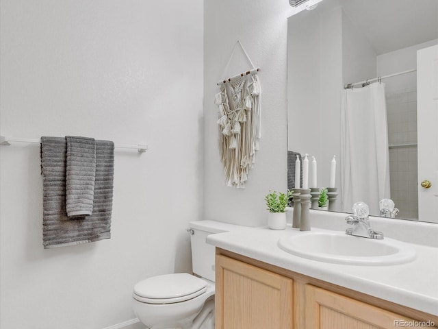 bathroom featuring toilet, vanity, and a shower with curtain