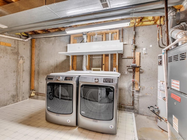 laundry room featuring washing machine and dryer, water heater, and heating unit