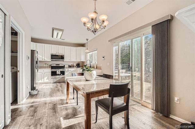 dining area featuring a notable chandelier and light hardwood / wood-style floors