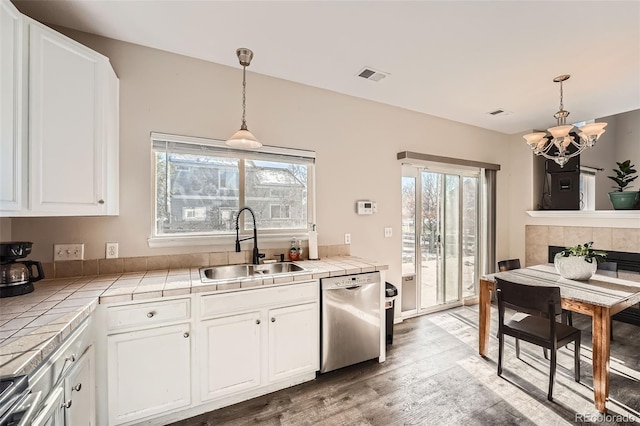 kitchen featuring tile counters, white cabinets, stainless steel appliances, and sink