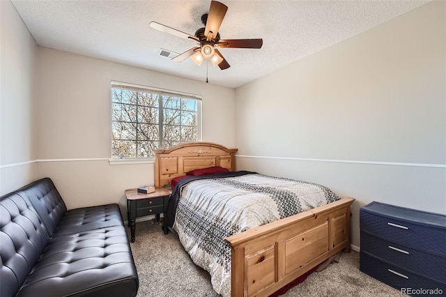 bedroom featuring ceiling fan, light carpet, and a textured ceiling