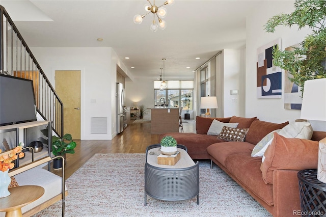 living room with hardwood / wood-style flooring and an inviting chandelier