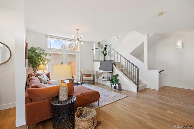 living room featuring a notable chandelier and light wood-type flooring