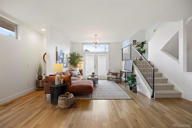 living room with light hardwood / wood-style floors and a chandelier