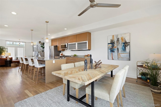 dining room featuring french doors, ceiling fan, sink, and light hardwood / wood-style floors