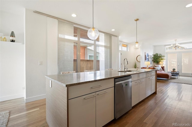 kitchen with pendant lighting, dishwasher, sink, and white cabinets