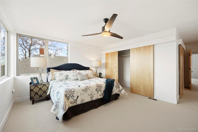 carpeted bedroom featuring ceiling fan and a closet